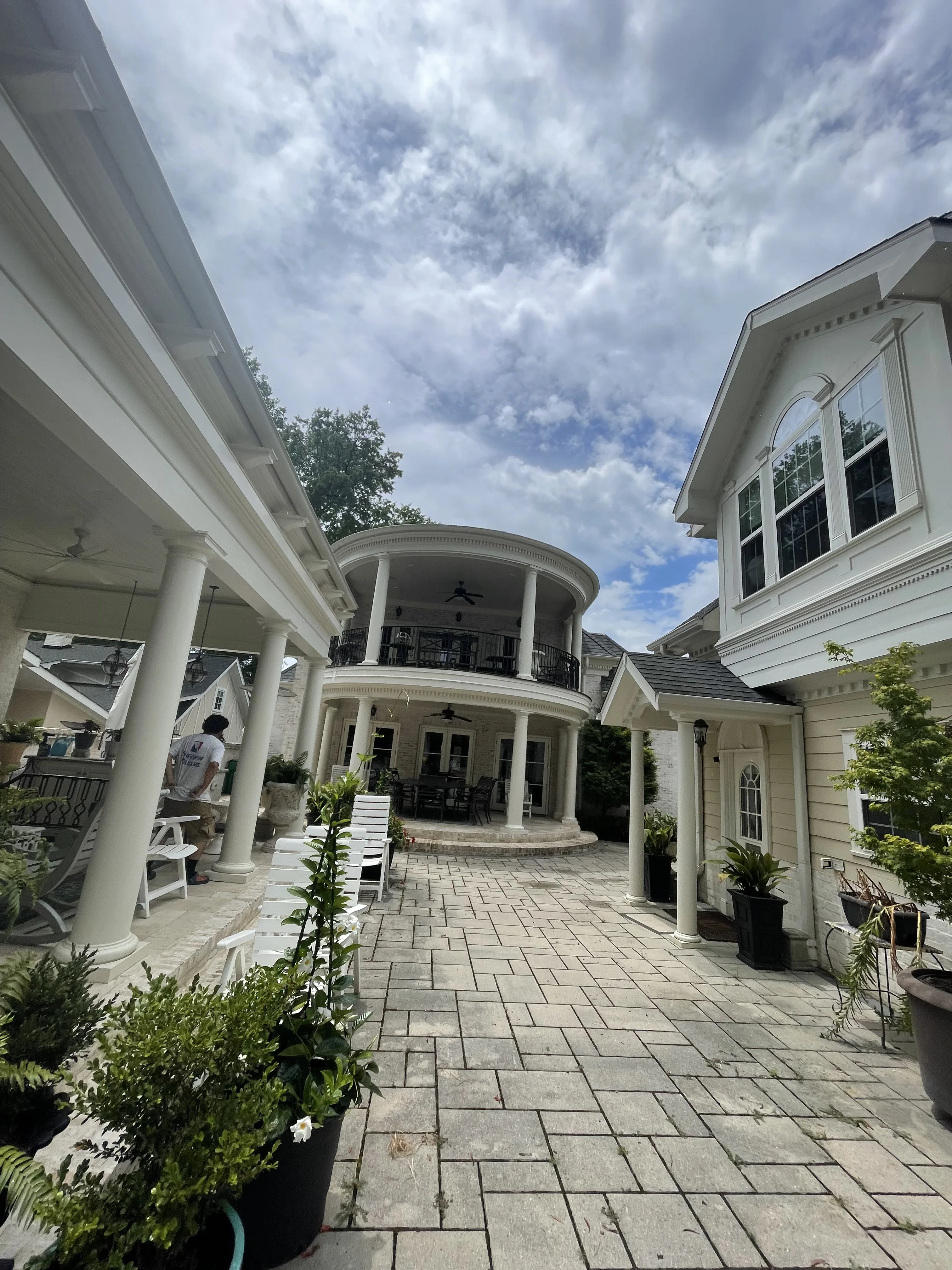 White painted residential exterior with columns, portico, and architectural trim details