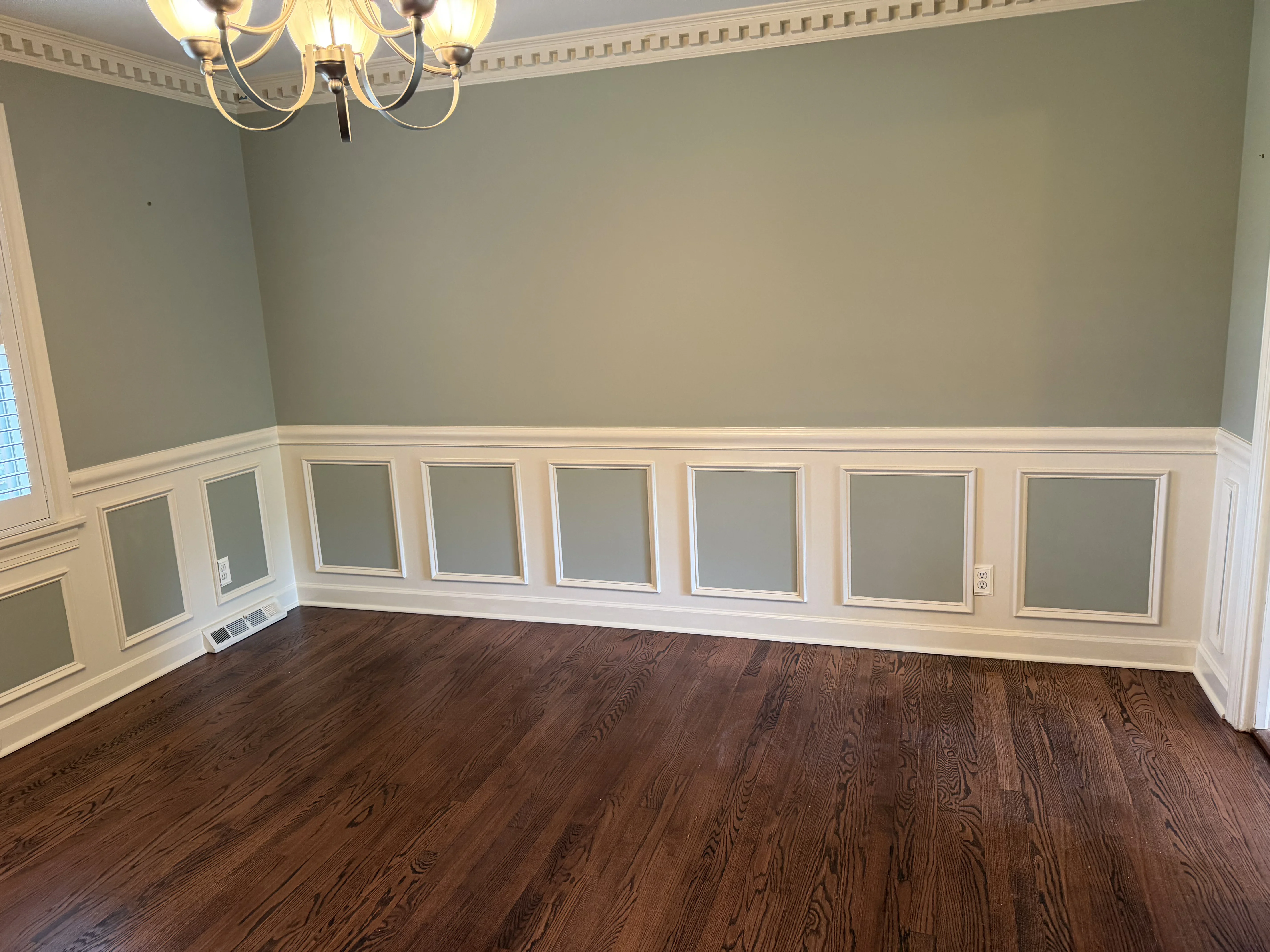Two-tone painted walls with white wainscoting, crown molding, and sage green upper walls